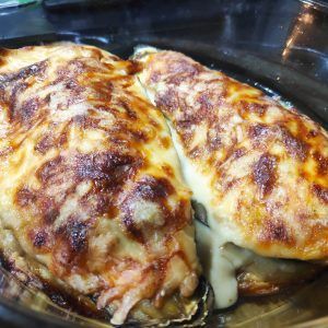 dos berenjenas rellenas de carne al horno con queso gratinado encima