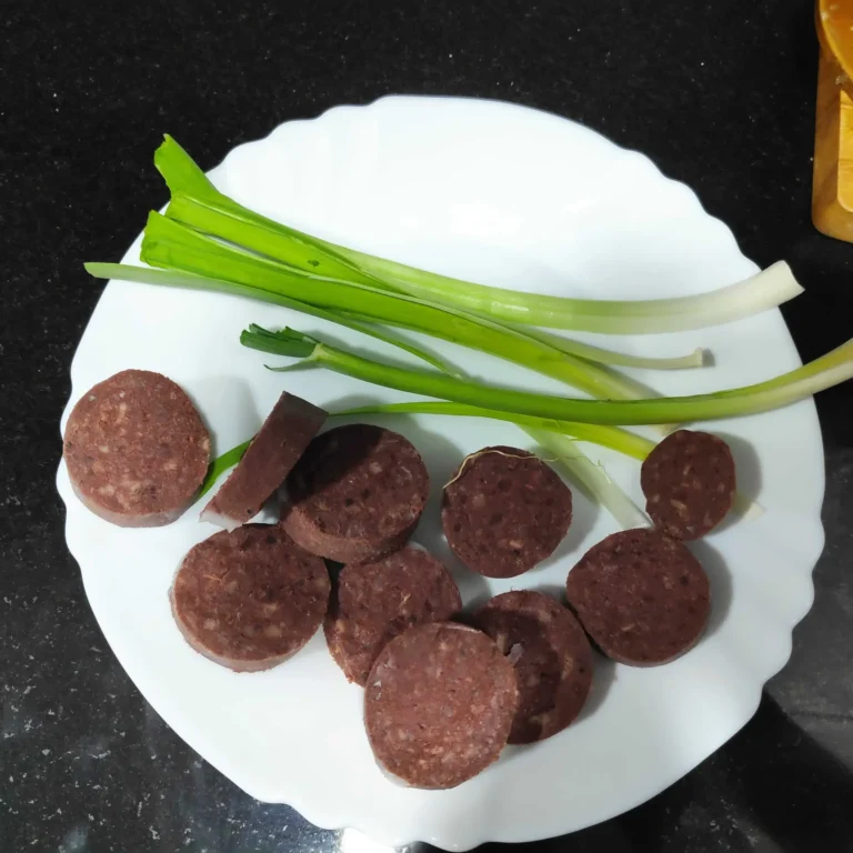 rodajas de butifarra negra y ajos tiernos para elaborar las habas a la catalana