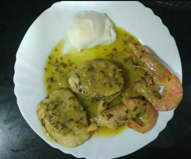 plato de merluza en salsa verde con gambas y un huevo poché