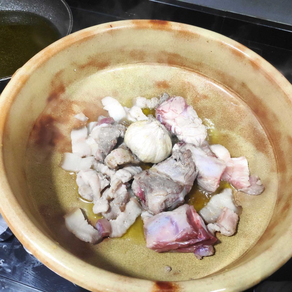 una cazuela de barro, con carne friéndose