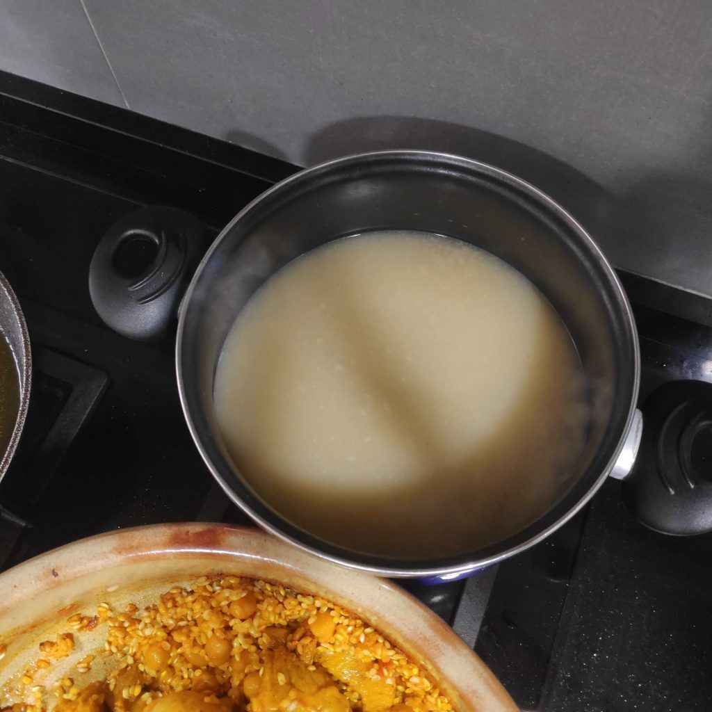 una cazuela con caldo al fuego