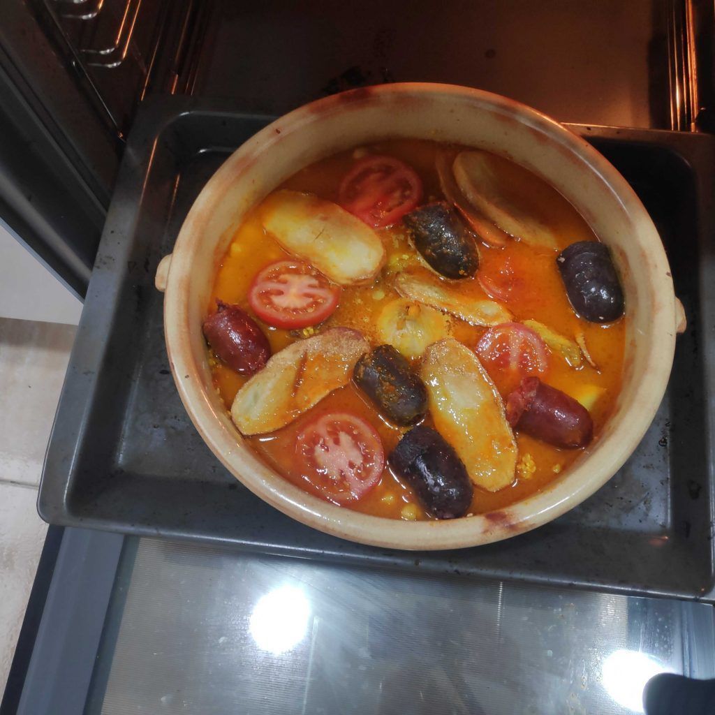 el horno abierto y la cazuela con el caldo a punto para hornear