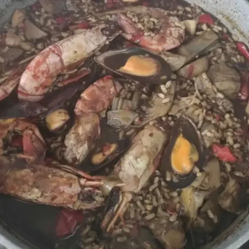 arròs negre casolà amb carxofes i gambes a la cassola