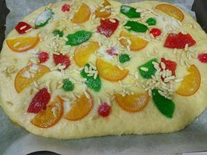 coca de frutas confitadas con azúcar y piñones antes de hornear
