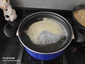 una cazuela azul al fuego con el caldo