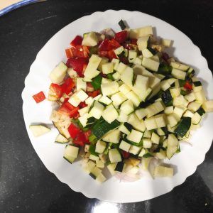 en un plato cortado da cuadraditos, pimiento,berenjena calabacín y cebolla.