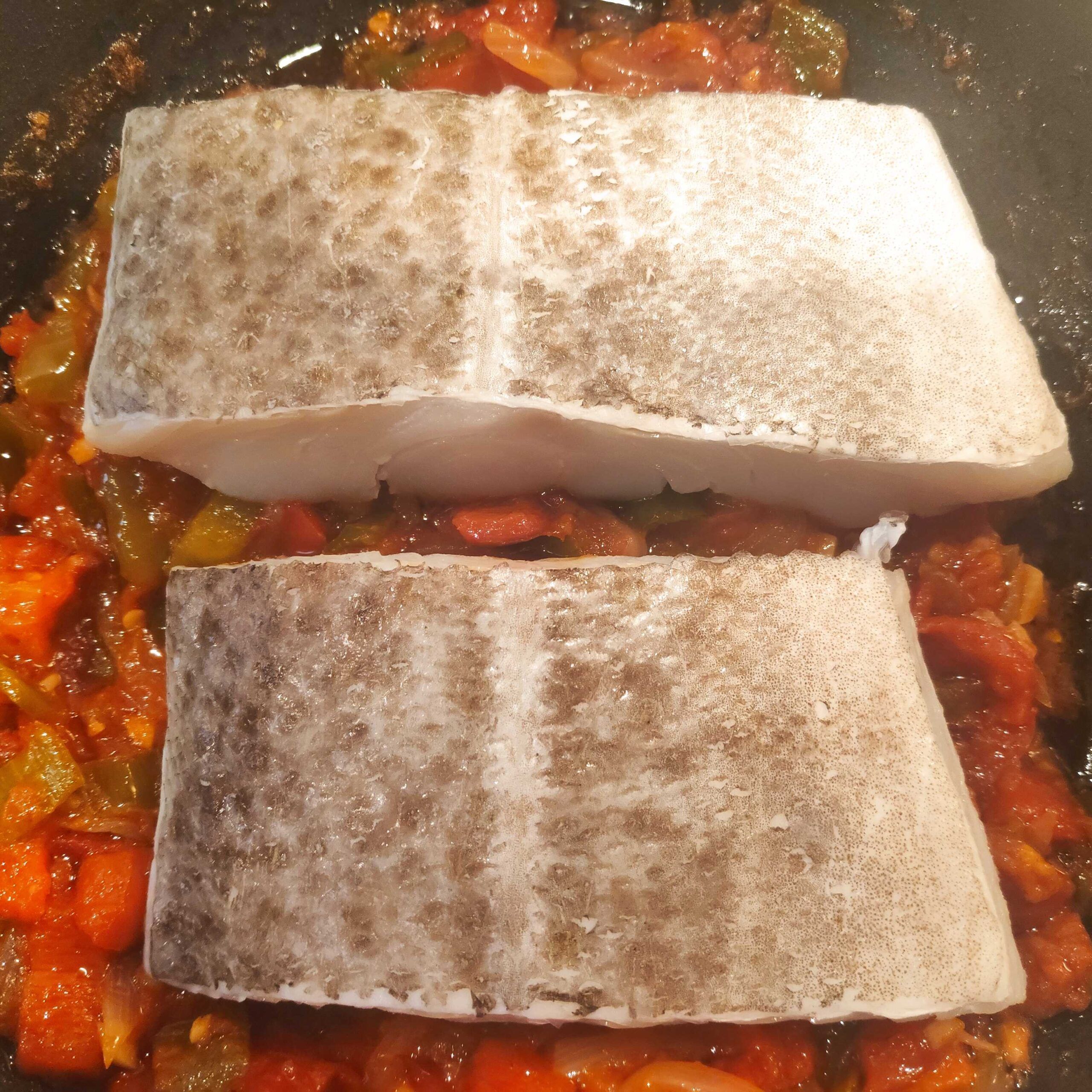 dos lomos de bacalao añadidos sobre la salsa de aajoarriero