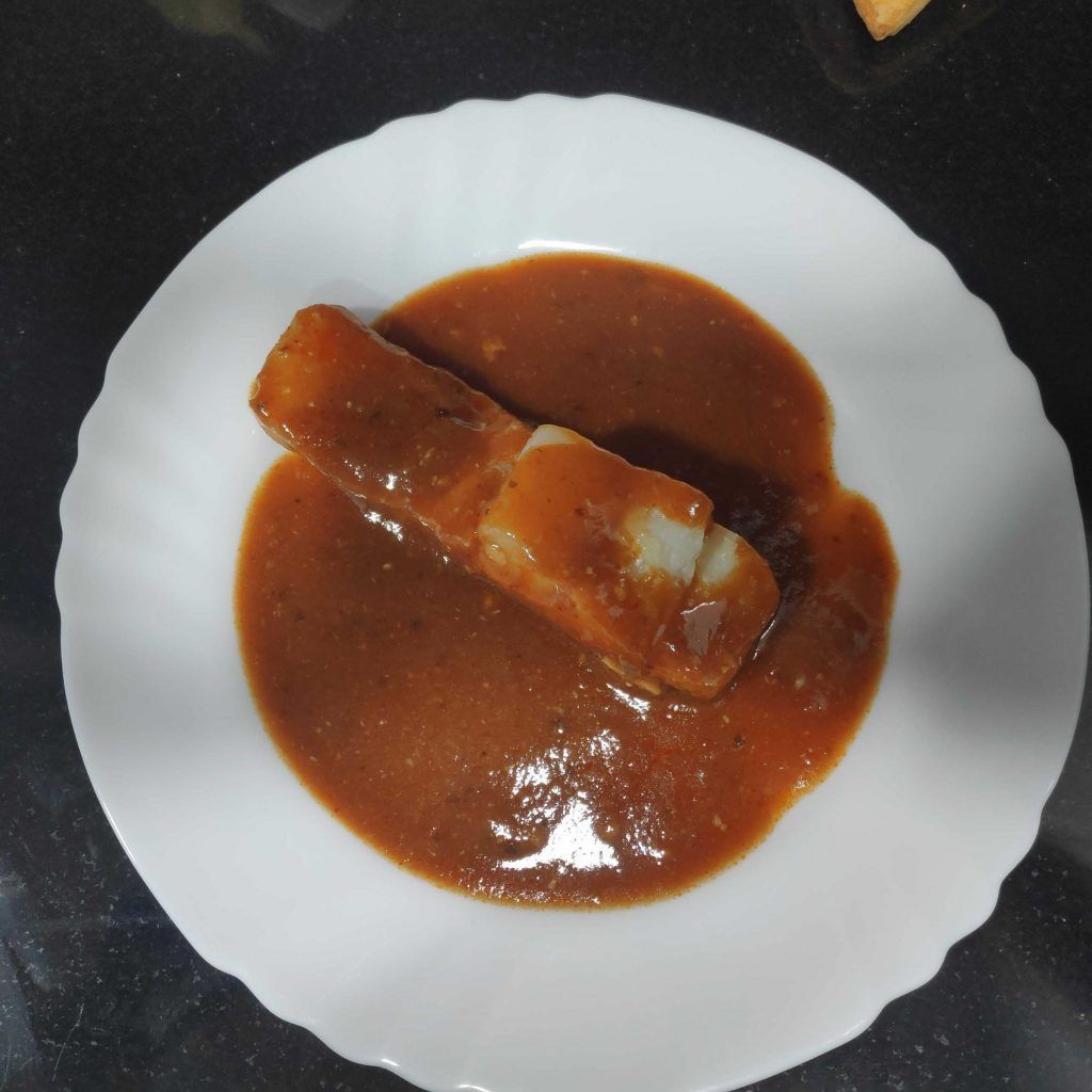una ración de bacalao a la vizcaína con salsa en un plato