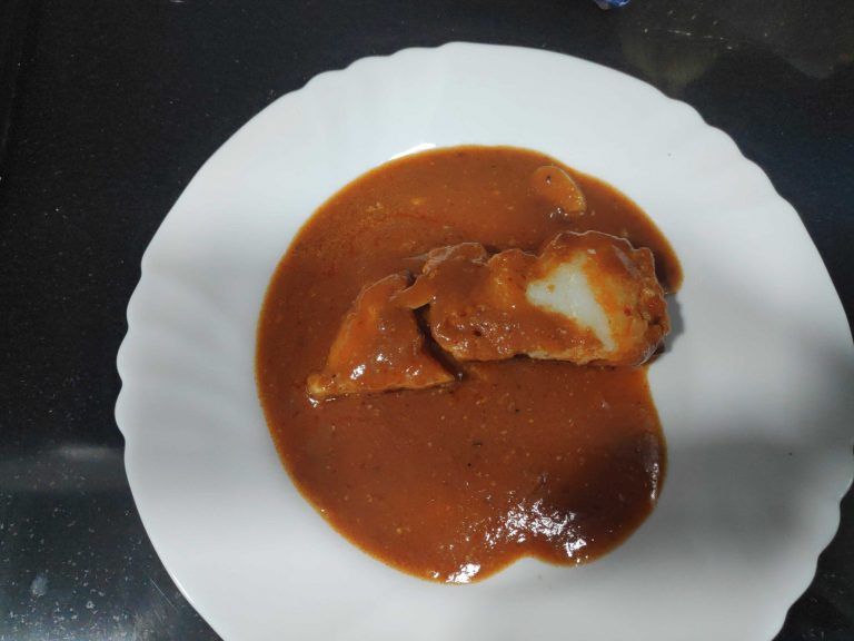 un plat blanc amb una porció de bacallà a la biscaina