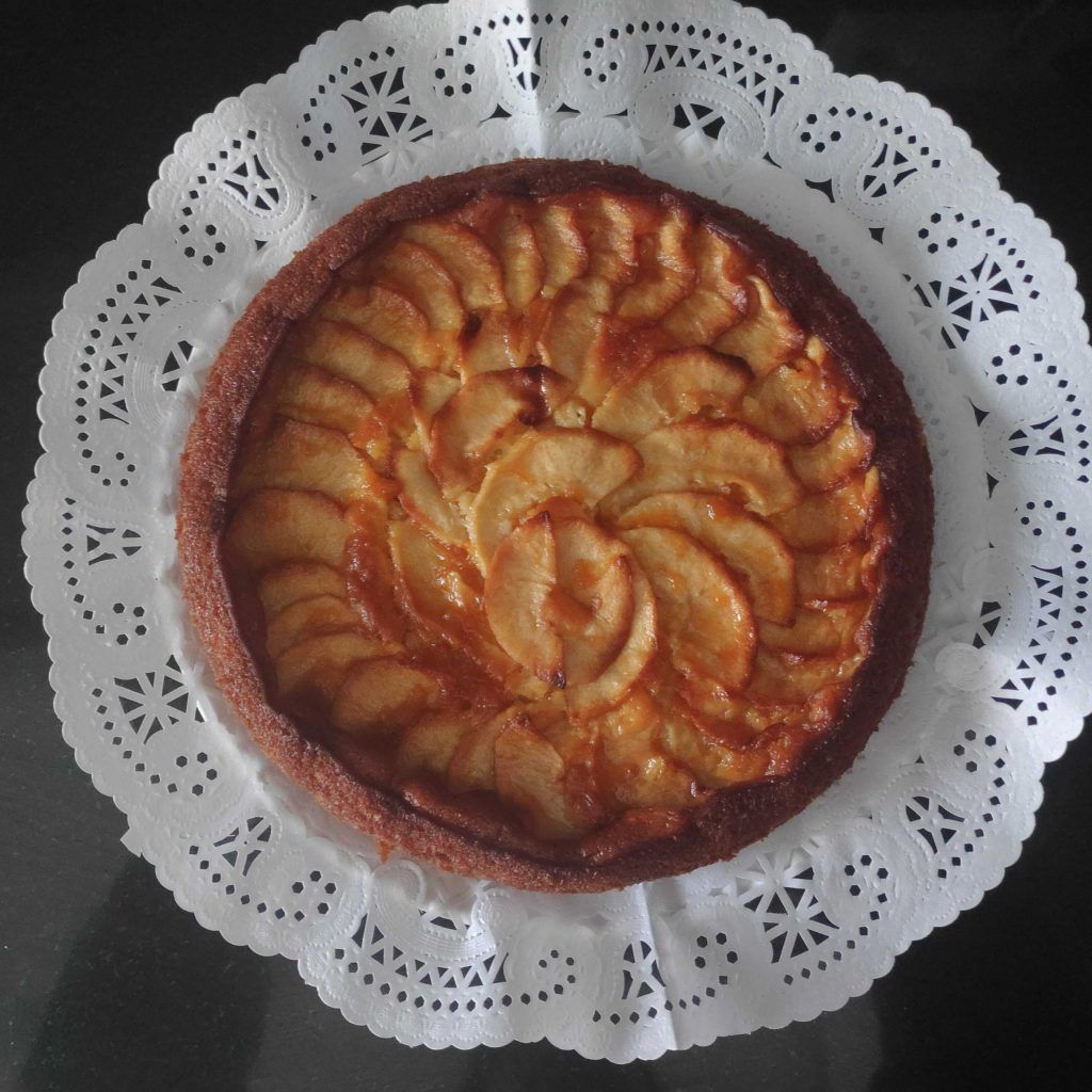 una tarta de manzana redonda sobre blonda blanca