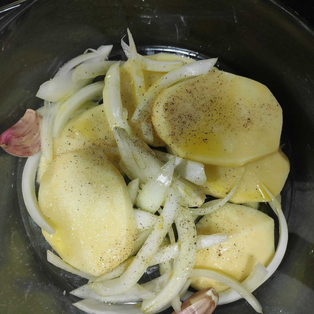 patates i ceba salpebrats en una safata de forn per enfornar el braó