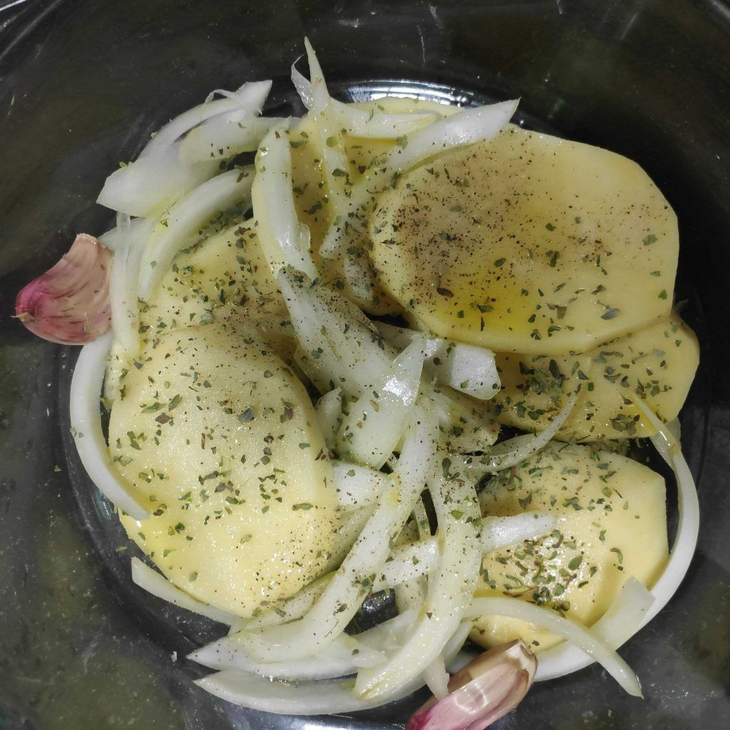 llit de patates i ceba consimentada per enfornar el braó de porc