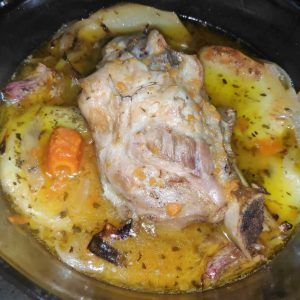 codillo de cerdo al horno con patatas al horno en una fuente