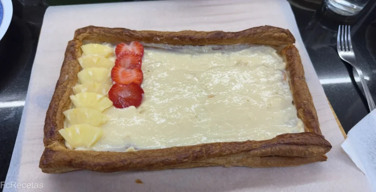 colocando frutas sobre la crema en lel hojaldre de frutas y crema