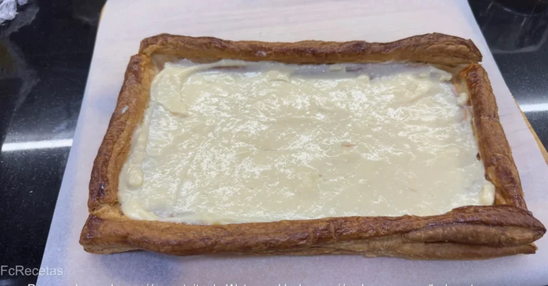 una capa de crema en la placa de hojaldre para la tarta de hojaldre con crema y frutas