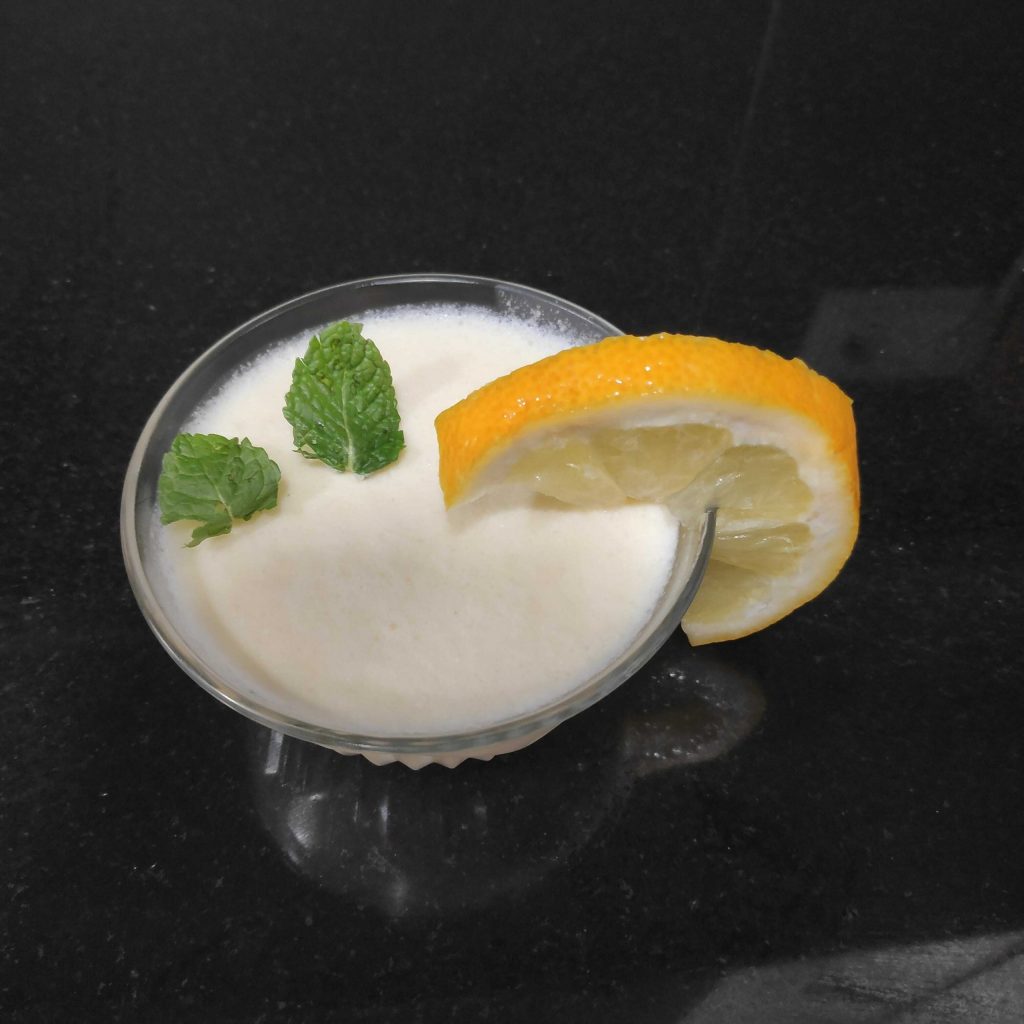 vasito de postre de limón con adorno de menta y rodaja de limón