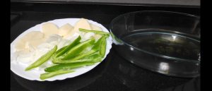 en un plato patatas, cebolla y pimientos crudos cortados