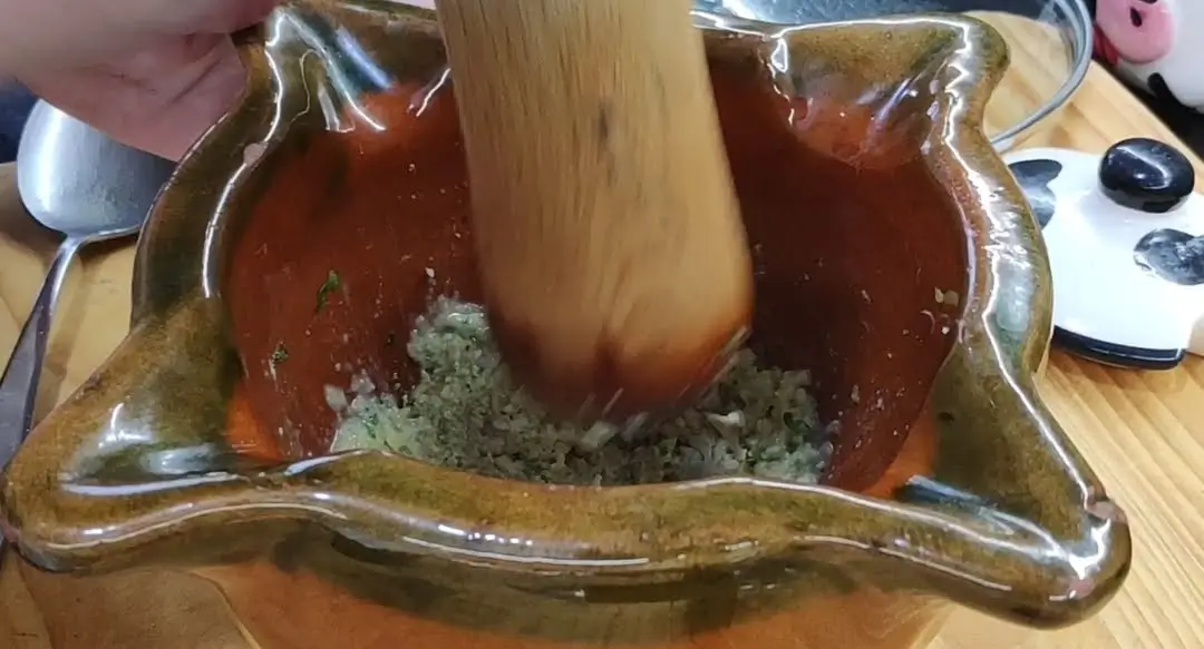 mortero elaborando la picada para la salsa del bacalao a la ampurdanesa