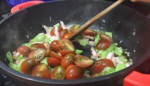 añadiendo los tomates cherry partidos por la mitad