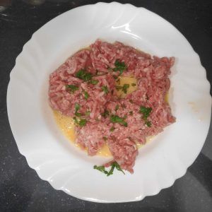 en un plato la carne picada añadida al huevo