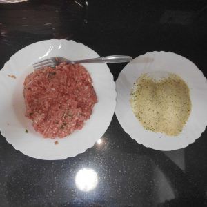 dos platos uno con carne picada y el otro con el pan rallado