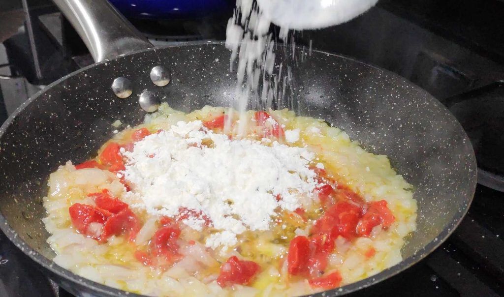 afegint farina a la paella