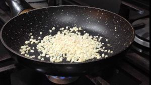 En una paella daurant crocanti d'ametlla