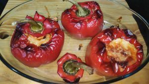 En una safata de forn tres pebrots farcits