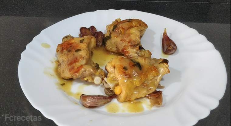 un plato con trozos de pollo con salsa al ajillo con ajos.