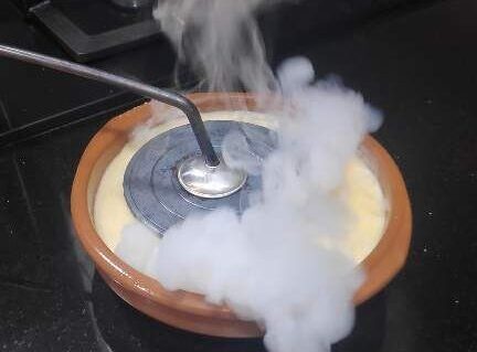 cremar sucre amb un tradicional cremador de ferro pas final de la preparació de la crema catalana