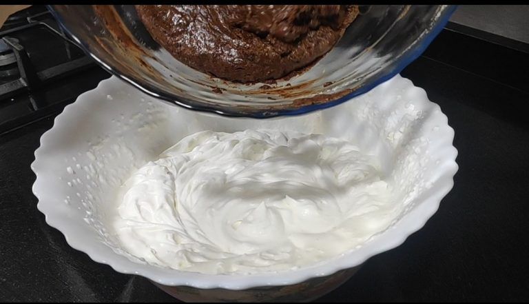 afegint la barreja de xocolata a la nata muntada