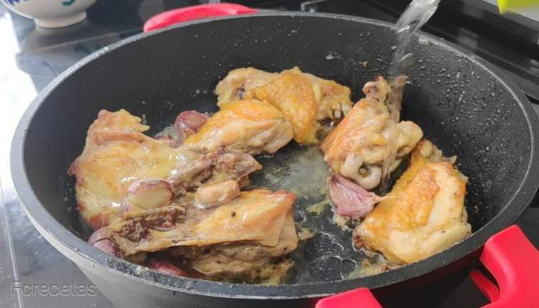 añadido vino blanco a la cazuela con el pollo y los ajos.