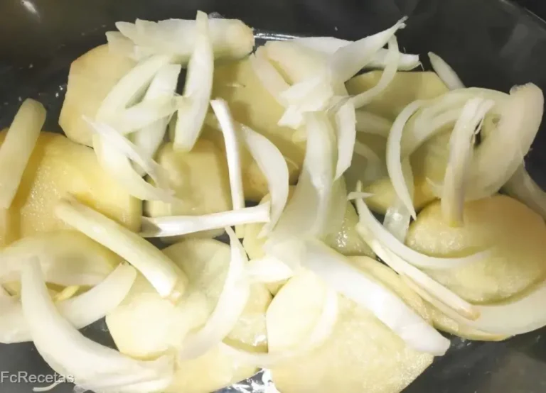 en una safata de forn, un llit de patates i ceba