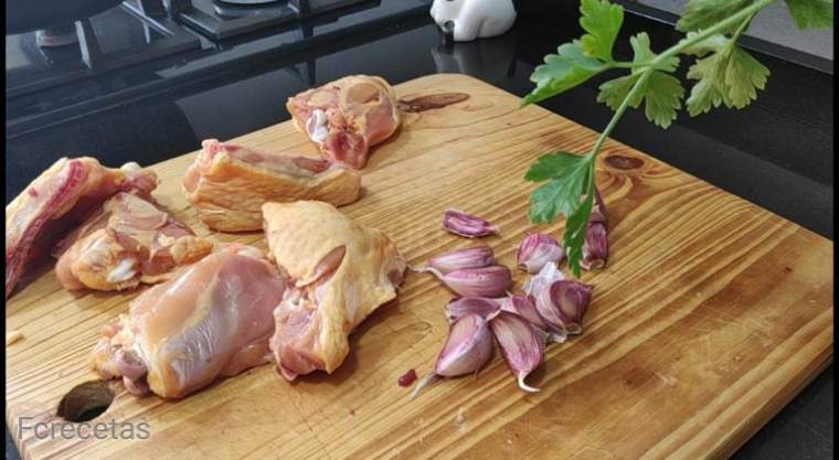 el pollo troceado en una tabla de madera salpimentado