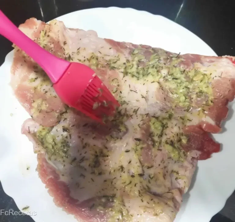amb una brotxa untant la picada a la carn del secret de porc