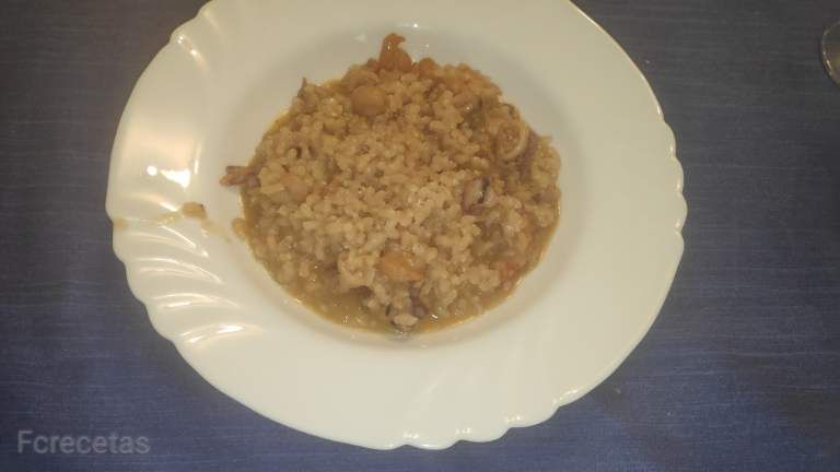 Un plato blanco con risotto de calamares