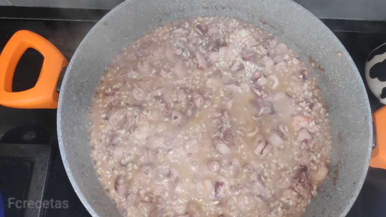 Cazuela con el vino añadido al Risotto de calamares