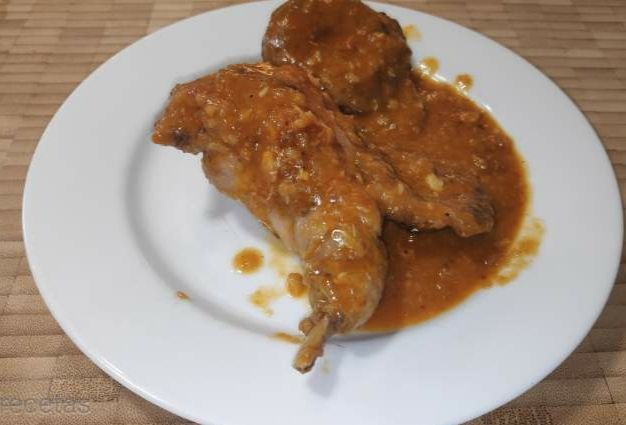 conejo con salsa de romesco y setas en un plato