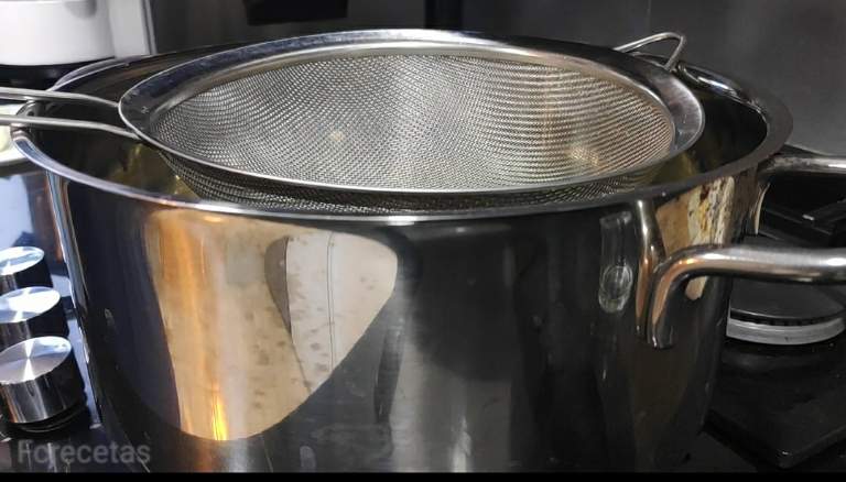 La cazuela con un colador encima, para colar el almíbar