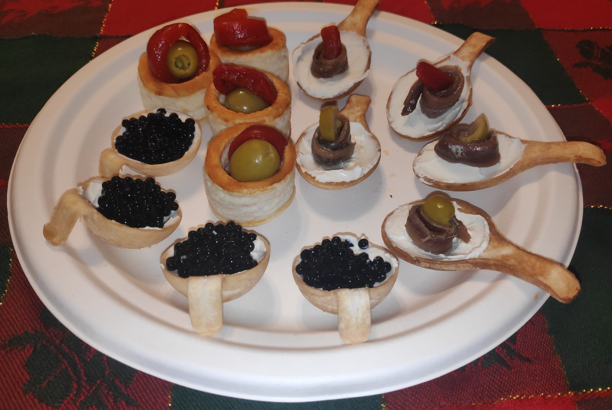 unas cucharitas rellenas de queso crema olivas, anchoas, etc tipo canapes