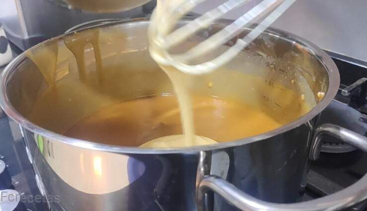 afegint la barreja dels rovells a la cassola del torró pas de preparació de la mousse de torró