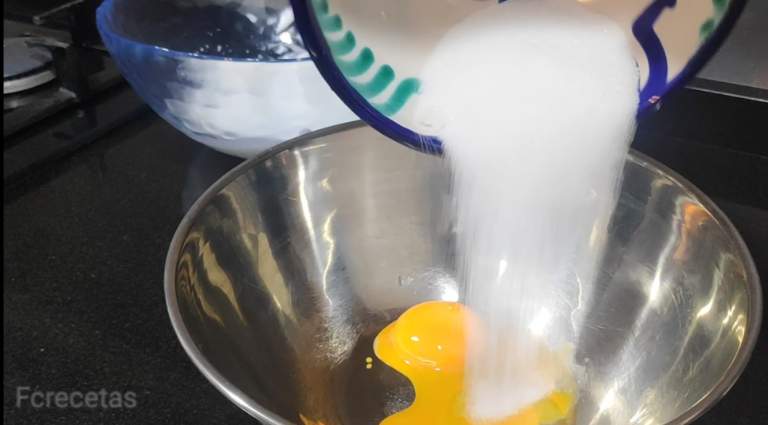 afegim el sucre als rovells que estan en un bol.
