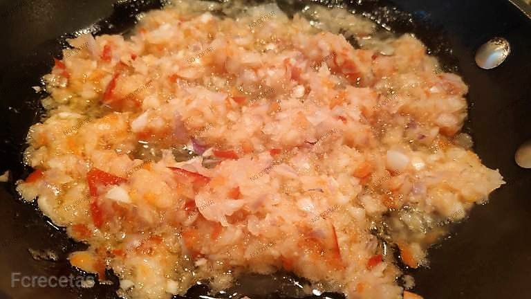 cebolla y ajo en la sartén para el sofrito de los calamares rellenos