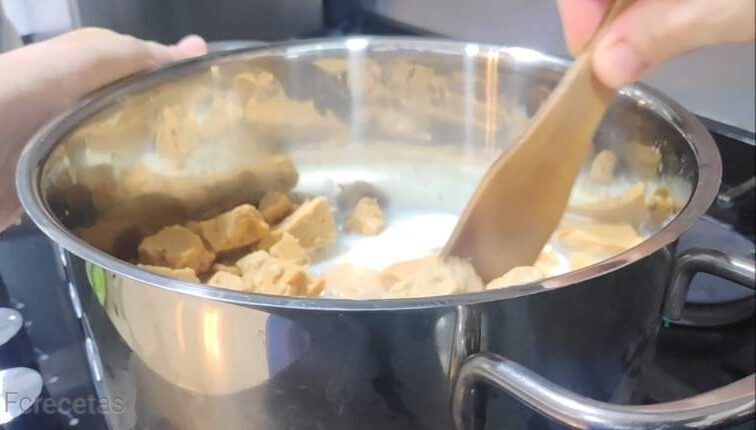 una cassola amb torró trossejat i llet preparació de la mousse de torró tou