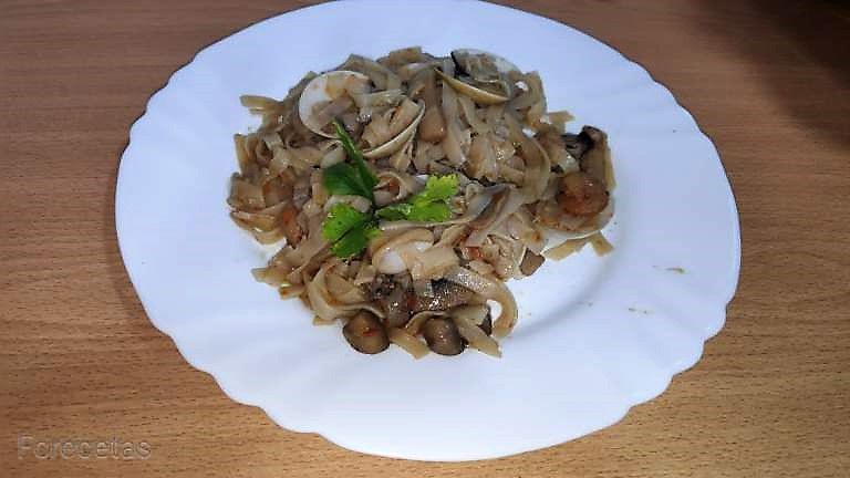un plato blanco con tallarines de arroz con pescado