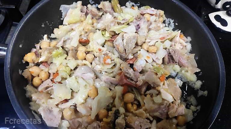 restos de cocido junto con la cebolla en la cazuela