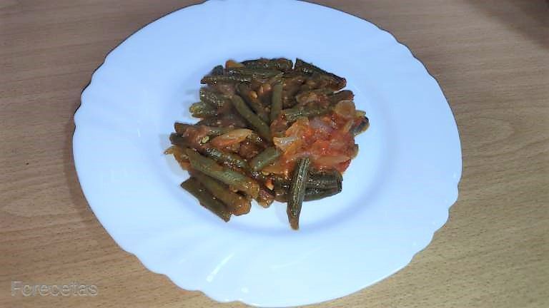 un plato blanco de judías verdes con tomate