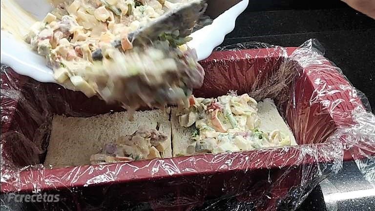 añadiendo la mezcla la primera capa sobre el pan de molde