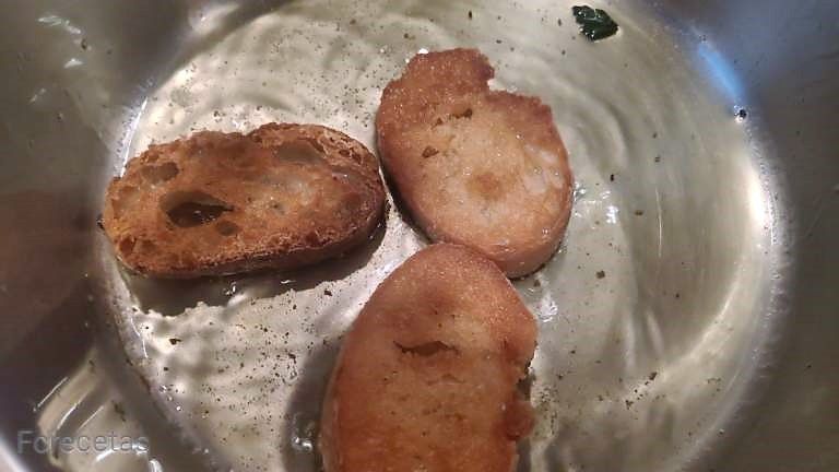 friendo tres rodajas de pan en la cazuela con aceite