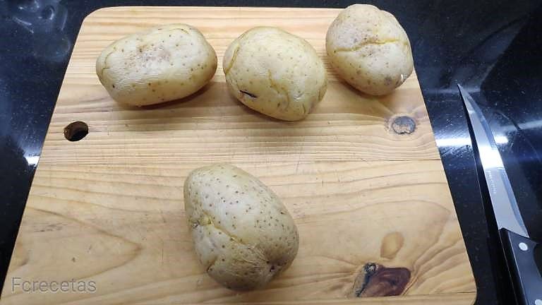 patatas cocidas con piel en una tabla de madera